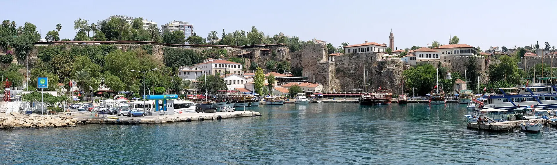Alter Hafen von Antalya mit Booten am Kai, darüber die Häuser der Altstadt Kaleiçi auf der Klippe und ein Minarett