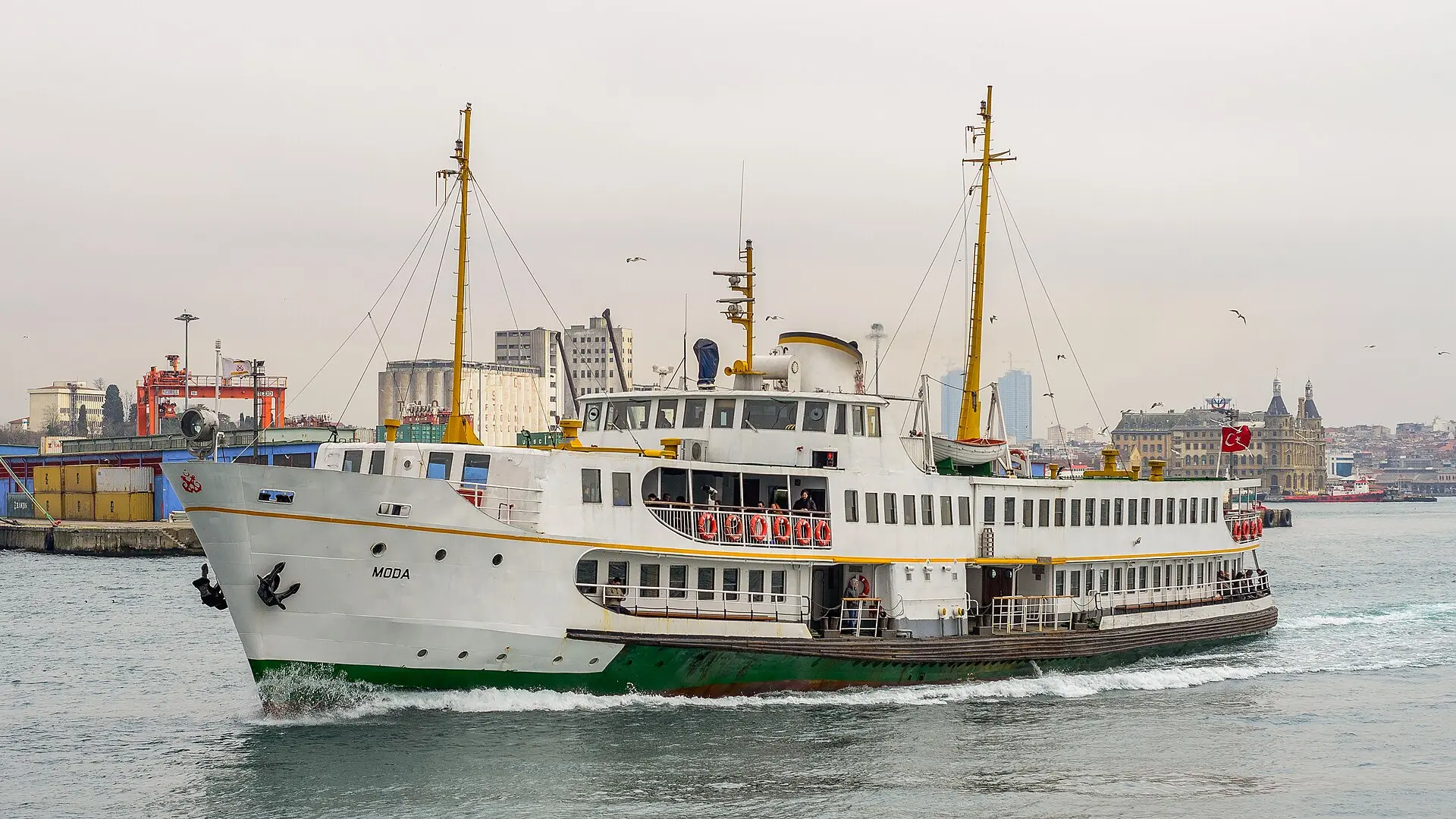 Klassische Istanbuler Stadtfähre mit dem Namen Moda in Fahrt vor dem Hafen Haydarpaşa, rechts hinten das Bahnhofsgebäude