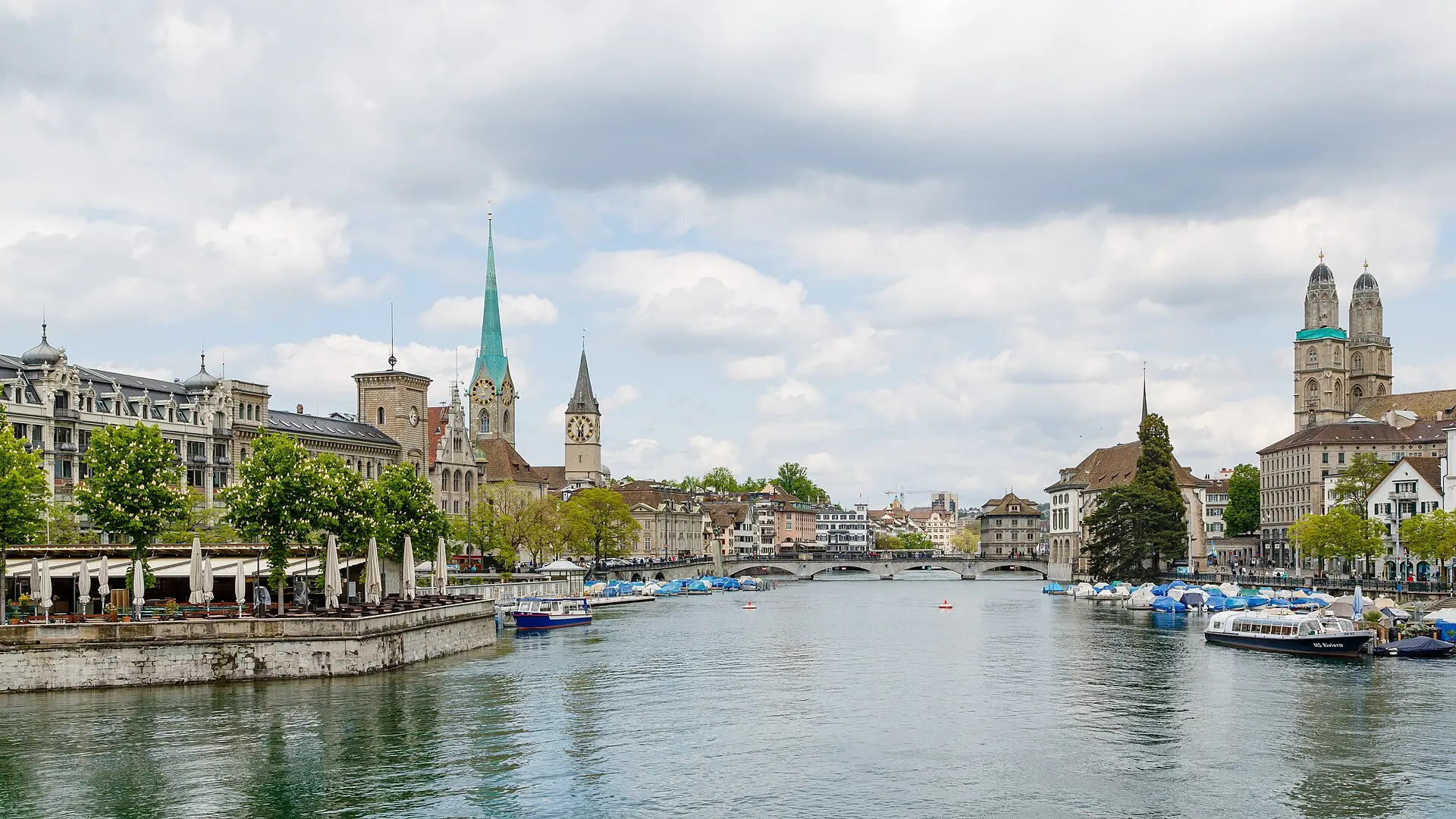 Blick von der Quaibrücke limmatabwärts auf Fraumünster, St. Peter mit Turmuhr, Münsterbrücke und die Doppeltürme des Grossmünsters