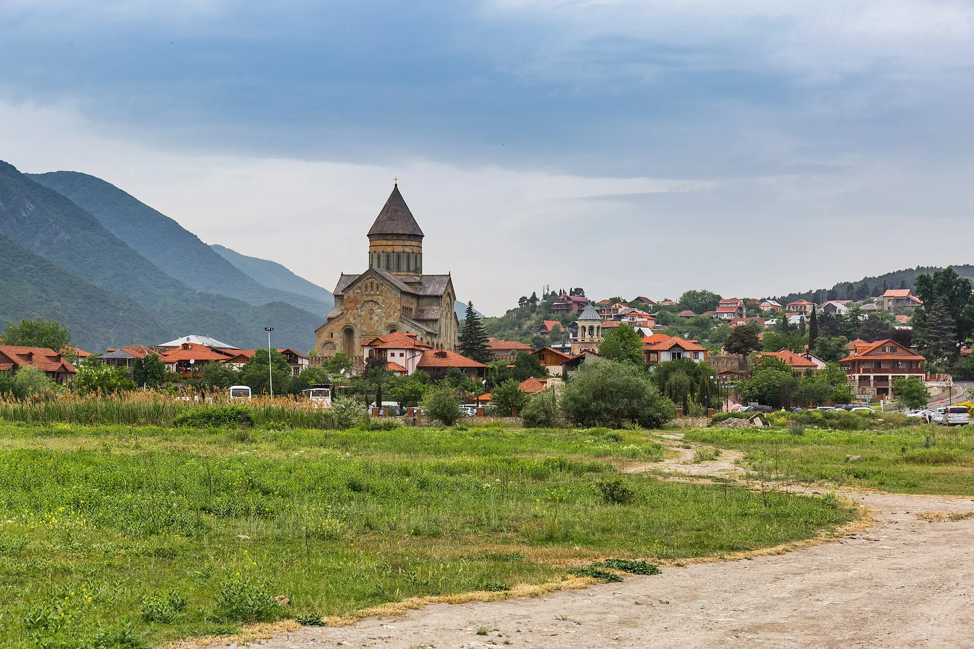 Swetizchoweli-Kathedrale in Mzcheta zwischen Wohnhäusern, im Hintergrund Berge