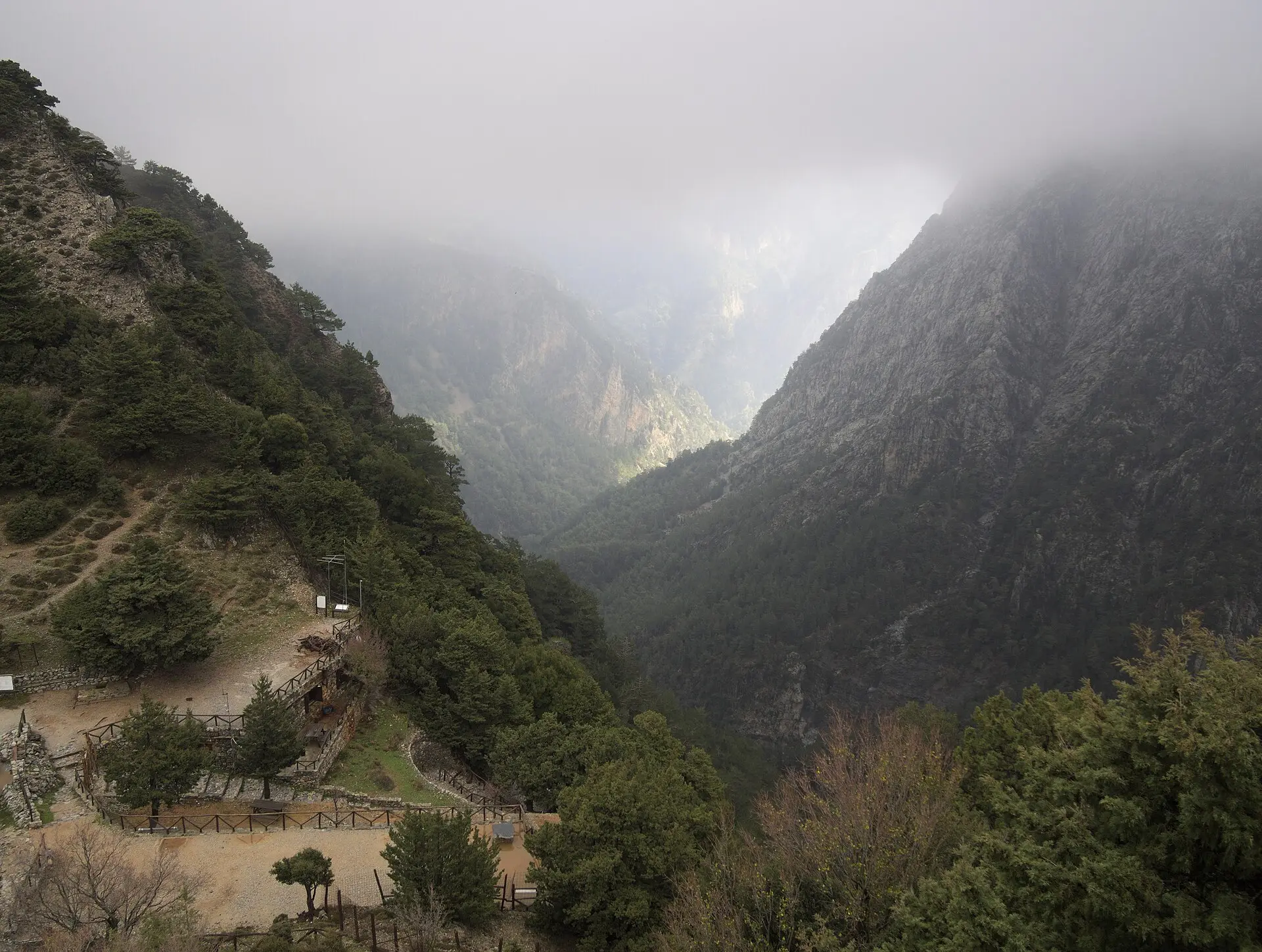 Blick vom Einstieg Xyloskalo in die nebelverhangene Samaria-Schlucht, links ein Rastplatz mit Holzgeländern