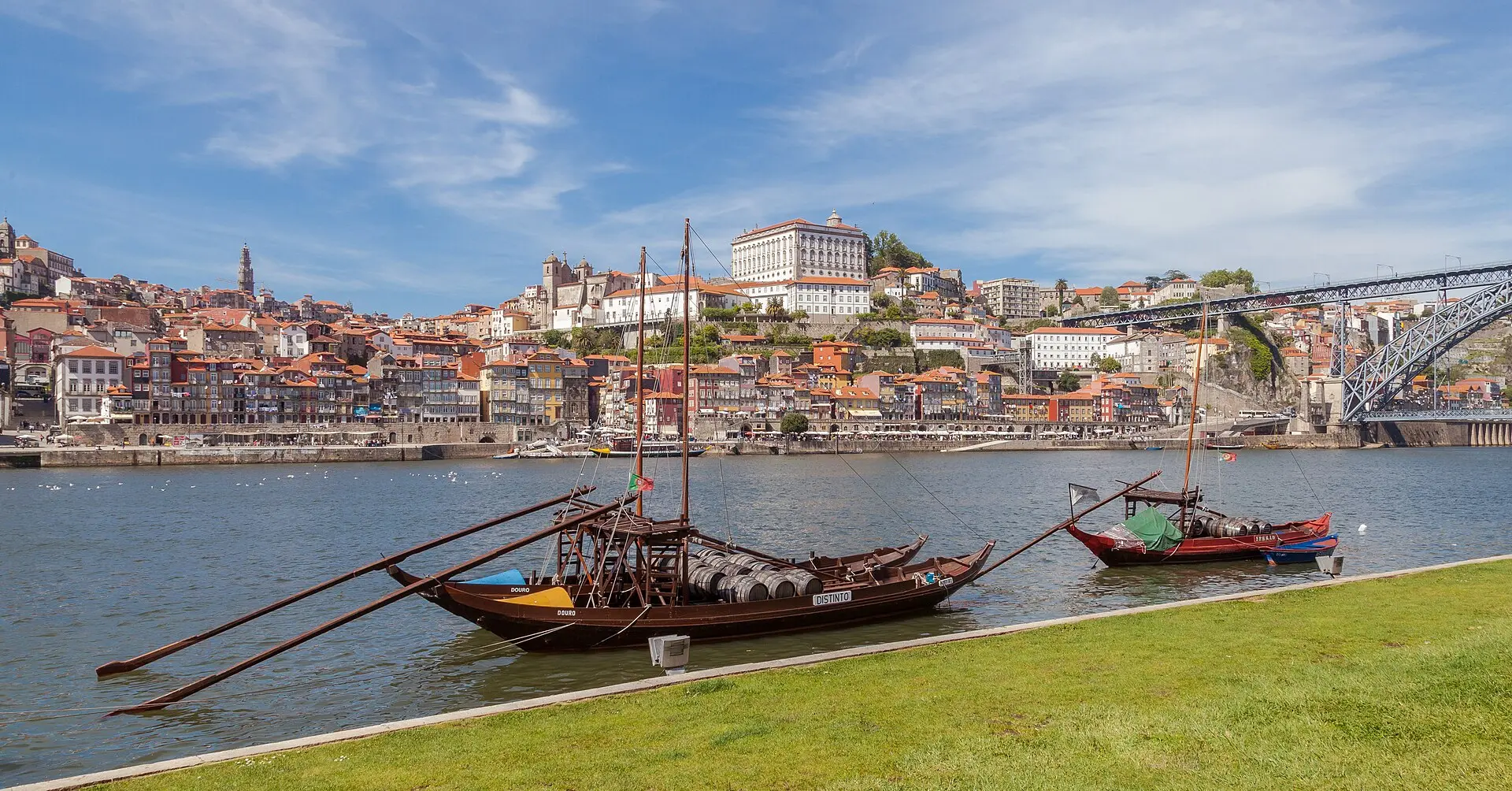 Zwei Rabelo-Boote mit Fässern am Ufer von Vila Nova de Gaia, gegenüber die Häuser der Ribeira am Hang, rechts die Brücke Luís I