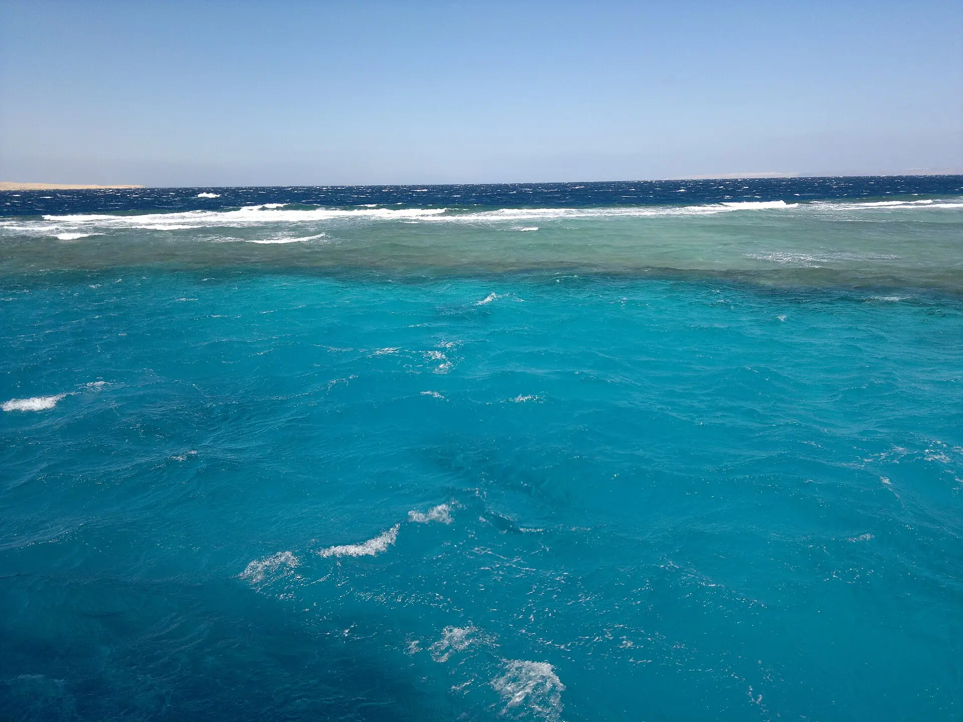 Wellen mit Schaumkronen über einer Riffkante vor Hurghada bei kräftigem Wind