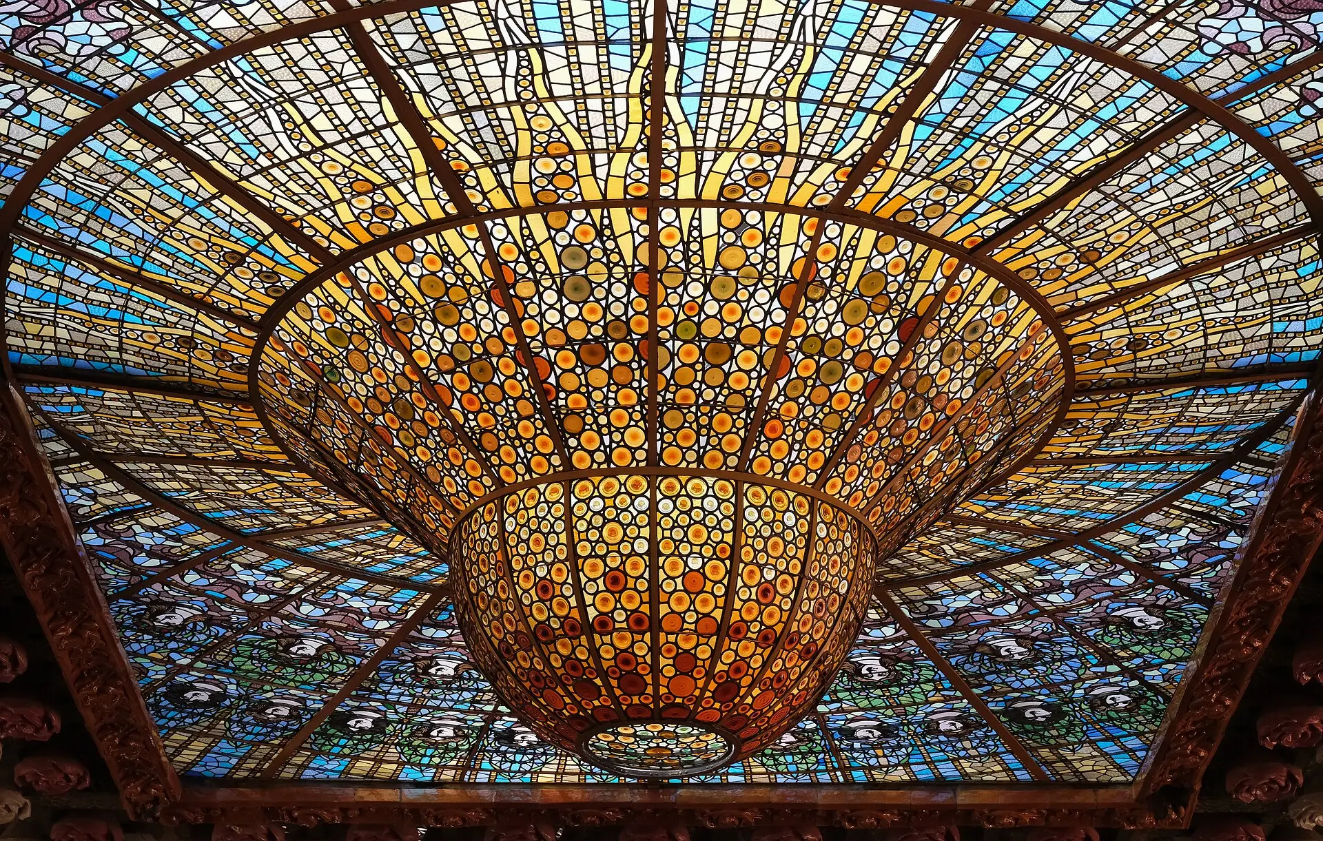 Buntglas-Oberlicht in Gold- und Blautönen an der Decke des Konzertsaals im Palau de la Música Catalana, von unten gesehen
