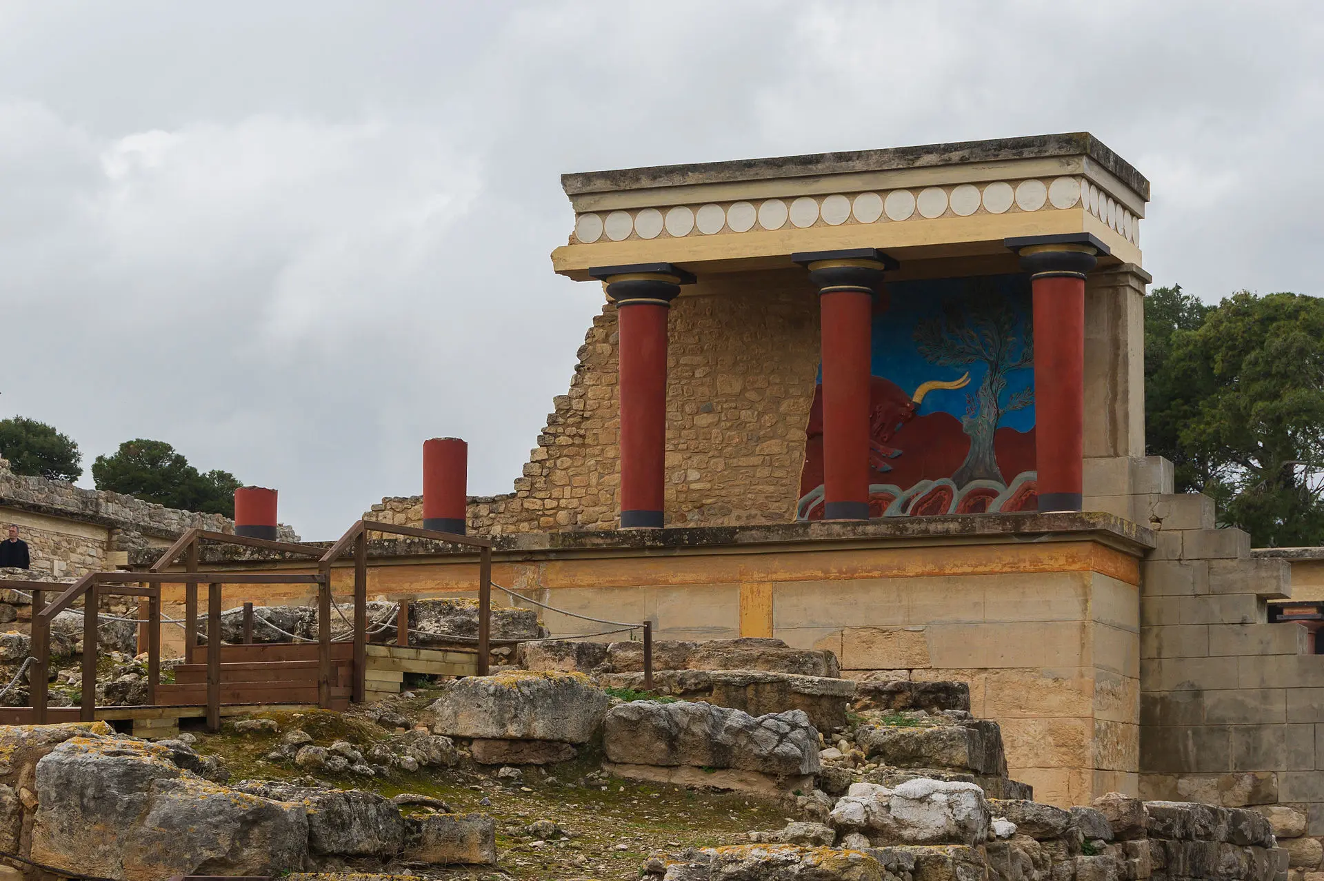 Rekonstruierte Säulenhalle am Nordeingang des Palasts von Knossos mit roten Säulen und einem Stierfresko an der Wand