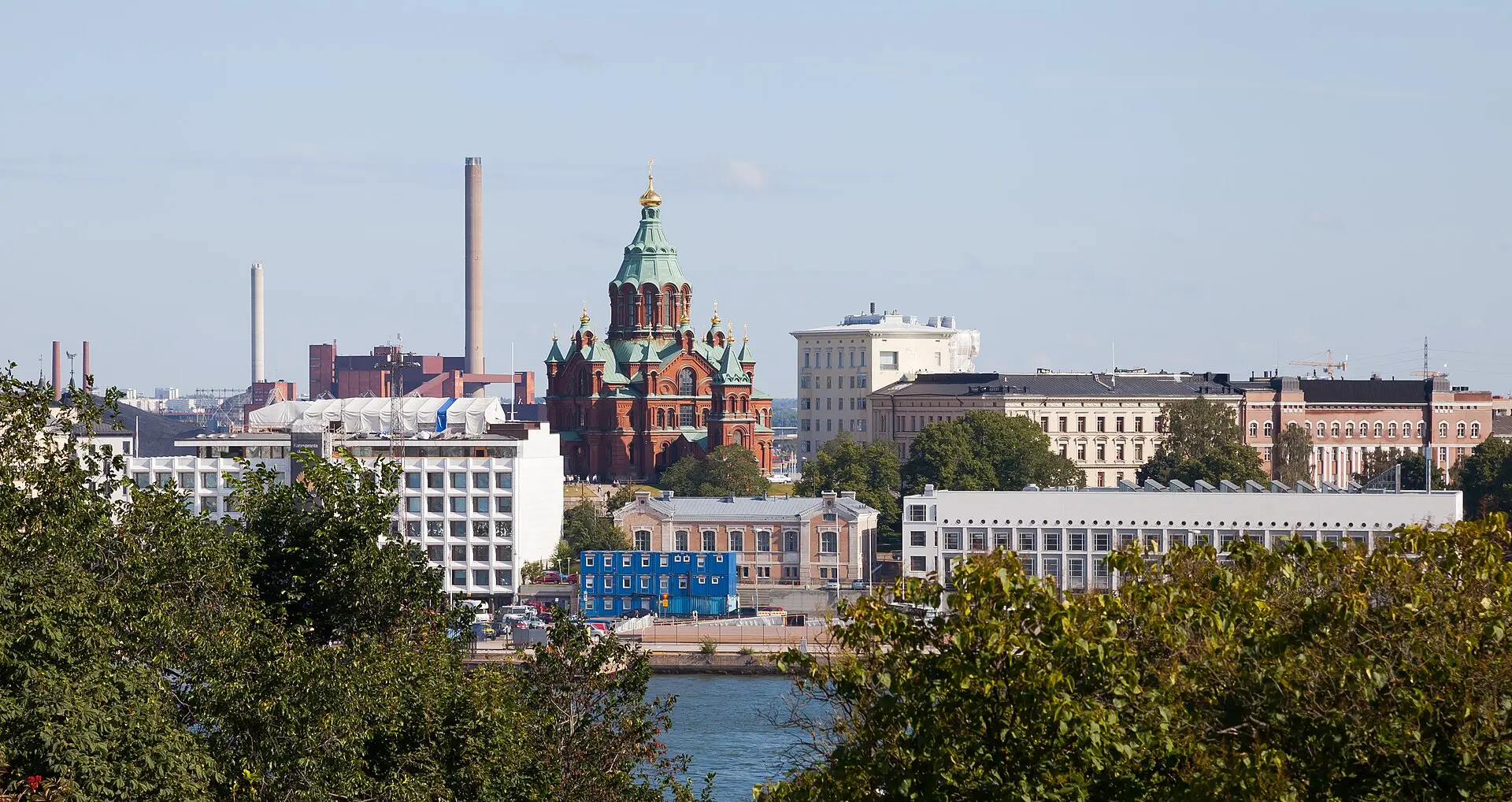 Die Uspenski-Kathedrale aus der Ferne: rote Backsteinkirche mit grünen und goldenen Kuppeln über Hafengebäuden