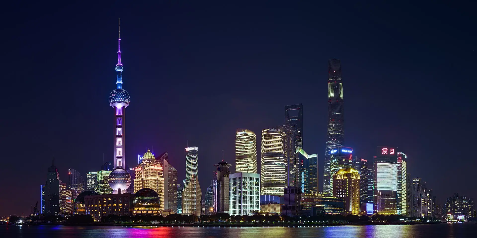 Skyline von Pudong in Shanghai bei Nacht über den Fluss hinweg: Fernsehturm mit Kugeln, Shanghai Tower und Lichter im Wasser