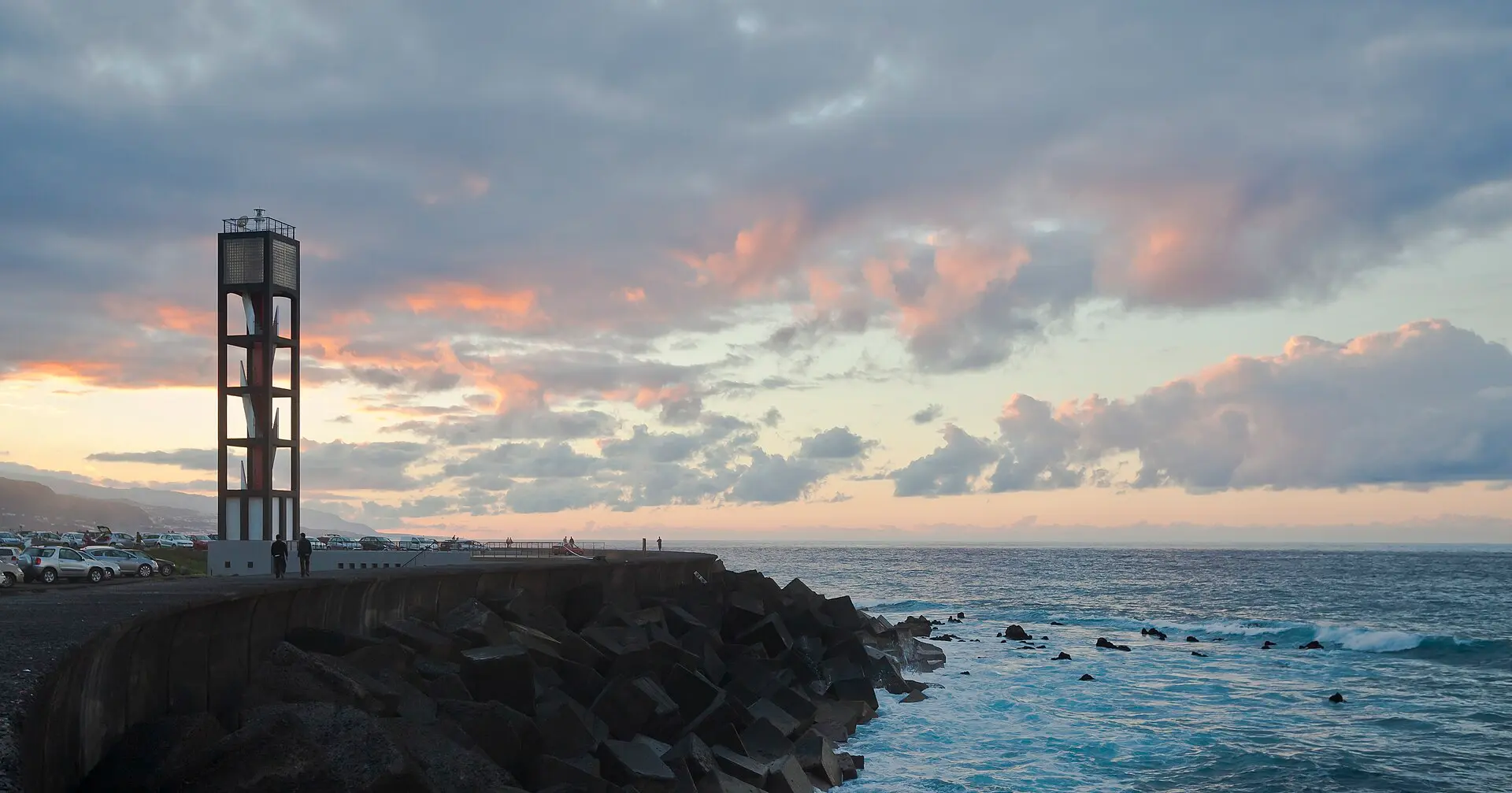Leuchtturm von Puerto de la Cruz bei Abendwolken und Brandung