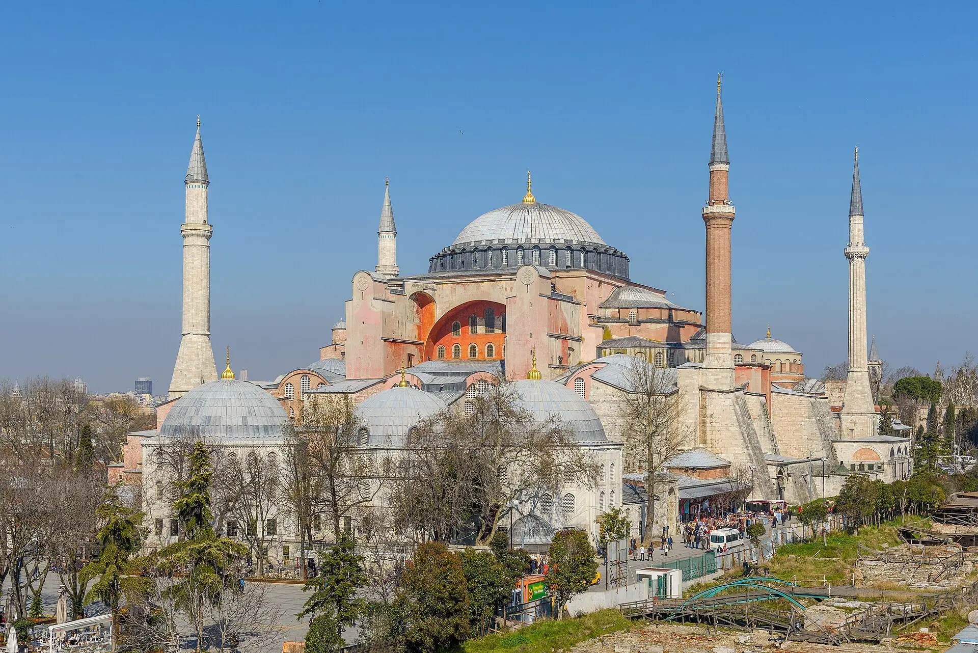 Hagia Sophia von außen bei klarem Himmel mit Hauptkuppel, Nebenkuppeln und vier Minaretten, davor kahle Bäume