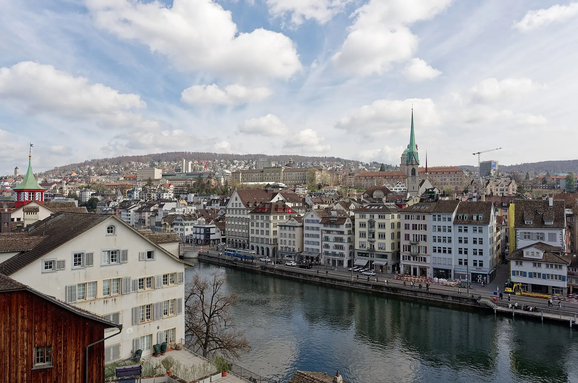 Blick vom Lindenhof über die Limmat auf die Häuser am Limmatquai, den grünen Turm der Predigerkirche und Hochschulbauten am Hang