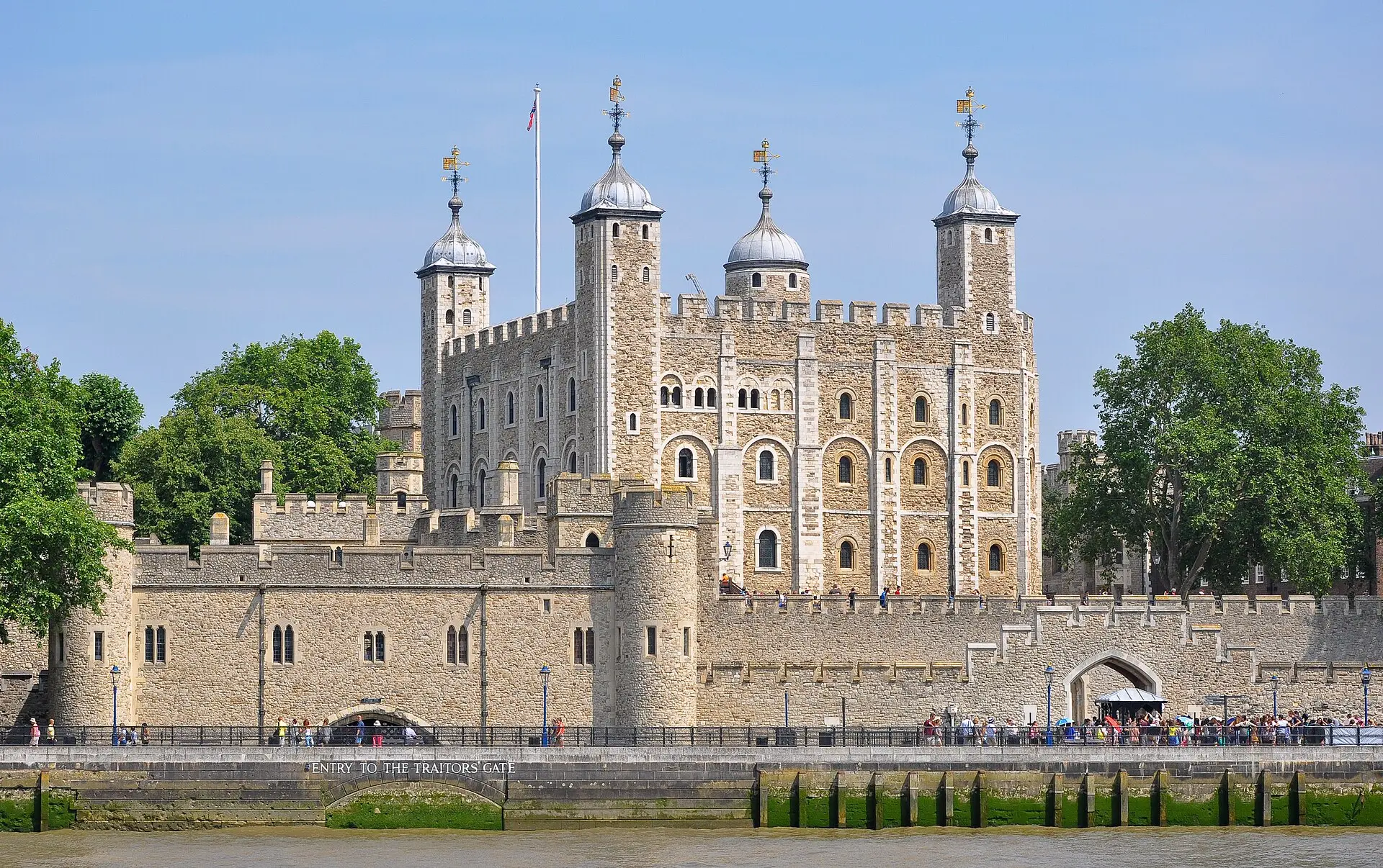 White Tower hinter der äußeren Mauer des Tower of London, darunter die Wasserpforte zum Traitors' Gate, von der Themse aus bei Sonne