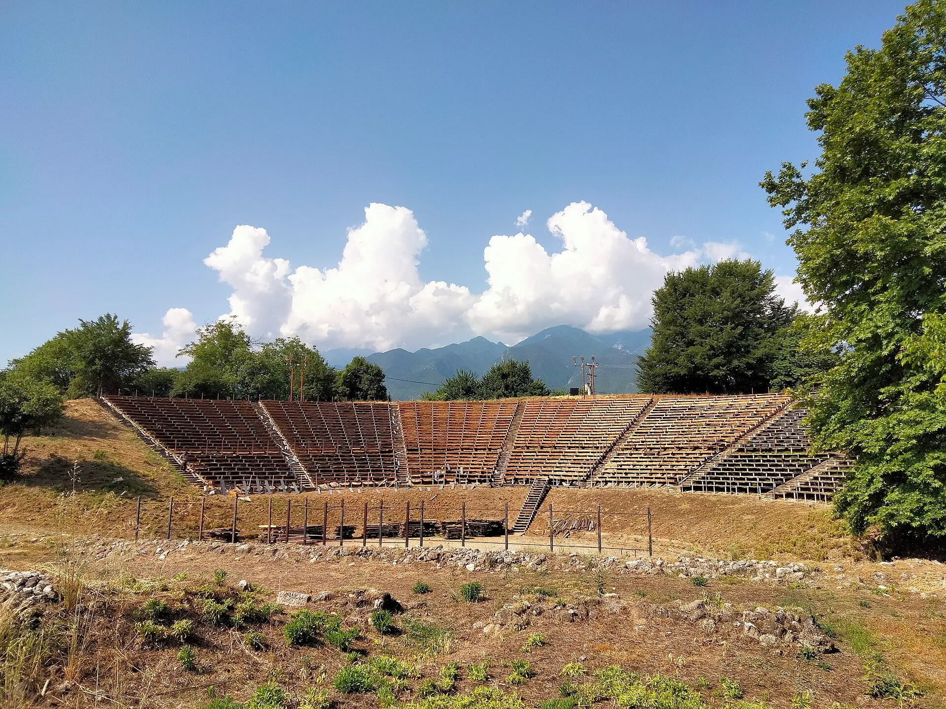 Hellenistisches Theater von Dion mit hölzernen Sitzreihen, dahinter das Olymp-Massiv unter Quellwolken